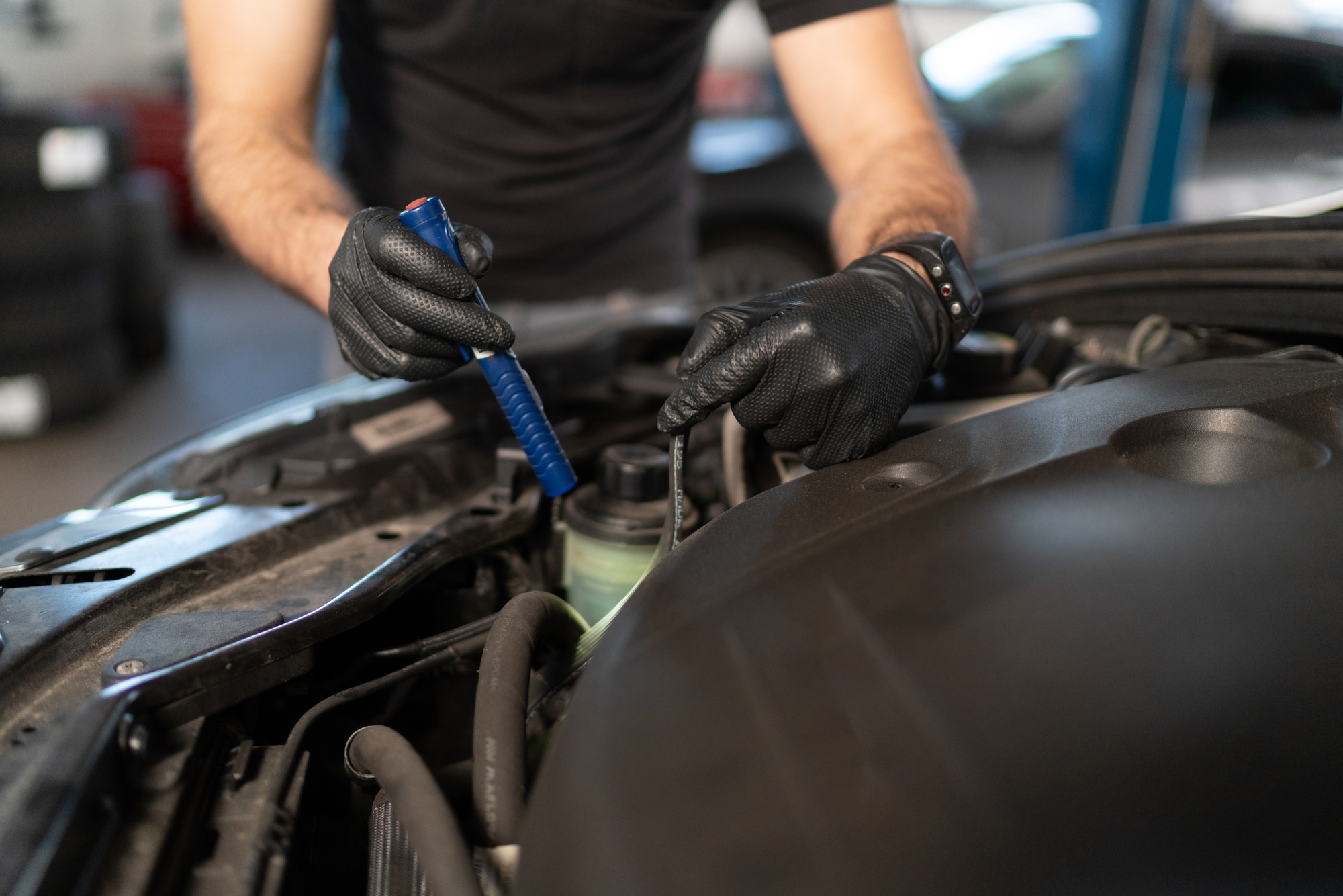Car repair technician checking car engine